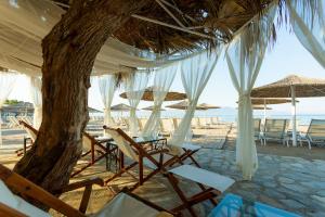 a group of chairs and umbrellas on a beach at CHARM BEACH HOTEL in Akyarlar