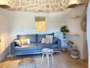 a living room with a blue couch and a table at Trullo Cinderella mit Mountainbike & Pool in Martina Franca