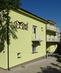 um edifício amarelo com um sinal na lateral em Vila Jenic em Soko Banja