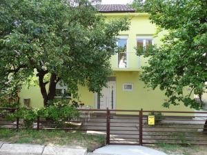 a yellow house with a fence in front of it at Vila Jenic in Soko Banja