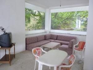 - un salon avec un canapé, une table et des chaises dans l'établissement Stupar Apartmani, à Dojran