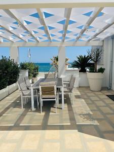 a table and chairs on a patio with a view of the ocean at La Caletta Suite Torre Canne in Torre Canne
