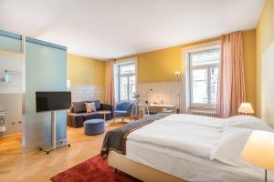 A bed or beds in a room at Alma Hotel
