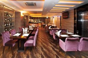 a restaurant with purple chairs and tables and a bar at Savoy Hotel Myeongdong in Seoul