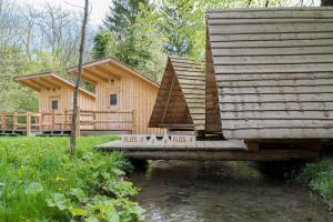 eine Blockhütte im Wald mit einer Veranda in der Unterkunft Kamp na Otoku - Ljubno ob Savinji in Ljubno