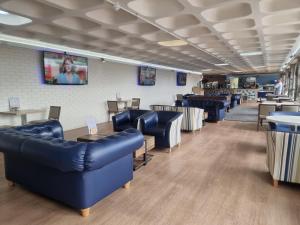 a waiting room with blue leather couches and tables at Static Caravan to Hire , Hoburne Devon Bay ( Paignton) in Goodrington