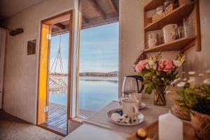 a table with a vase of flowers and a view of the water at Dzintarkrasts in Jūrmala