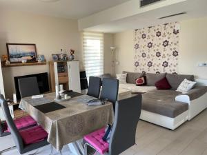 a living room with a table and a couch at Luxus Apartment direkt am See in Csopak