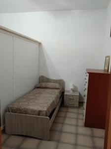 a small bedroom with a bed and a dresser at Olga’s house in Cariati