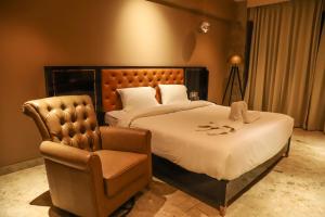 ナンデッドにあるVITS Bharat Nandedのベッド2台と椅子があるホテルの部屋