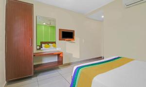 um quarto com uma cama e uma TV na parede em Itsy Hotels G Square em Vijayawāda mais 27 fotografias