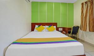 um quarto com uma grande cama branca e paredes verdes em Itsy Hotels G Square em Vijayawāda