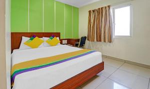 - une chambre avec un grand lit et une couverture arc-en-ciel dans l'établissement Itsy By Treebo - G Square, à Vijayawada