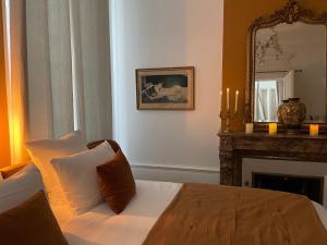 a bedroom with a bed with a mirror and a fireplace at Maison Marie-Astrid, Guest house , Suite avec Balnéo privée in Bordeaux