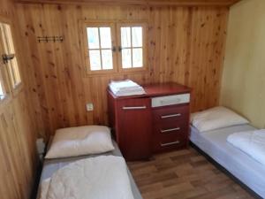 a room with two beds and a dresser in a cabin at Sport kemp Ejpovice in Ejpovice