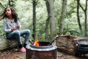 Une petite fille assise à côté d'un feu de camp dans l'établissement Drovers Rest, à Hay-on-Wye