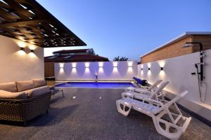 エイラットにあるWhite-Private pool Luxury Villa Eilatのラウンジチェア2脚とスイミングプールが備わるヴィラです。