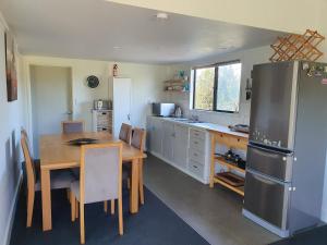 a kitchen with a wooden table and a refrigerator at Bookabarn in Kerikeri
