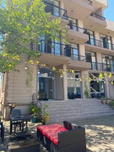 a building with a table and a red couch in front of it at Terassa Hotel Kobuleti in Kobuleti