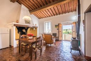een keuken en eetkamer met een tafel en een houtkachel bij La Dimora delle Volpi in Foiano della Chiana