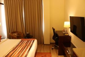 A bed or beds in a room at Regenta Inn Amristar Airport Road by Royal Orchid Hotels Limited