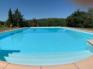 a large swimming pool with blue water at Lucignano apartments in Lucignano