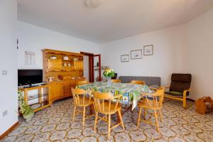 uma sala de estar com uma mesa de jantar e cadeiras em La Terrazza sul Mare em Magomadas