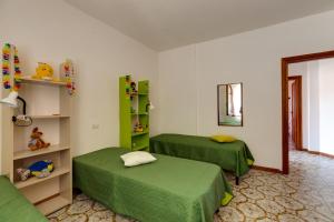 um quarto com 2 camas verdes e um espelho em La Terrazza sul Mare em Magomadas