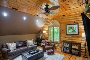 a living room with a couch and a ceiling fan at Iron Mountain Lodge - Beautiful Cabin With Forest & Mountain Views! in Butler