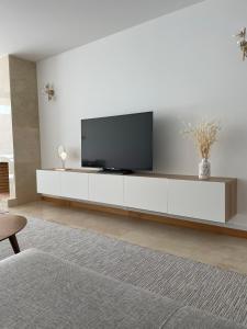 菲蓋拉－達福什的住宿－Figueira Centro Apartment by Rent4All，一间客厅,客厅的白色橱柜上配有电视