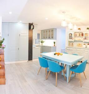 a kitchen with a white table and blue chairs at Lujoso y amplio piso con 5 habitaciones in Santiago de Compostela
