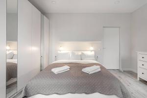 1 dormitorio con 1 cama con 2 toallas en HaPPy Inn VIP, Self Check-In-24x7, A-C, Parking-in-the-underground-Garage, en Vilna