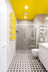uma casa de banho com um WC e um tecto amarelo em HaPPy Inn VIP, Self Check-In-24x7, A-C, Parking-in-the-underground-Garage em Vilnius