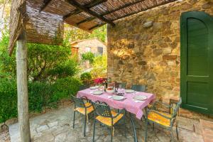 einen Tisch und Stühle auf einer Terrasse mit einer Steinmauer in der Unterkunft Piccolo Borgo Gagnoni in Sinalunga