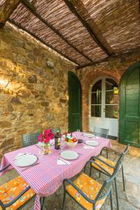 einen Tisch mit Tellern und Blumen auf einer Terrasse in der Unterkunft Piccolo Borgo Gagnoni in Sinalunga