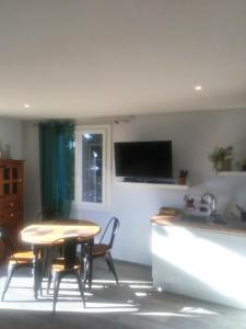 a kitchen with a table and chairs and a sink at Gite "villa lou félibre" in Vic-la-Gardiole