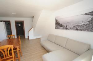 een woonkamer met een witte bank en een tafel bij Orange Park Apartamento Jardin in Benicàssim