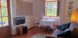 een woonkamer met een tafel en een televisie bij Monte da Xara in Aljezur