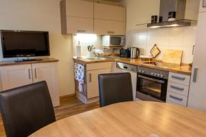 a kitchen with a table with chairs and a television at Ferienwohnung im Souterrain in Freest