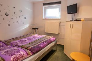1 dormitorio pequeño con 1 cama y TV en Ferienwohnung im Souterrain en Freest