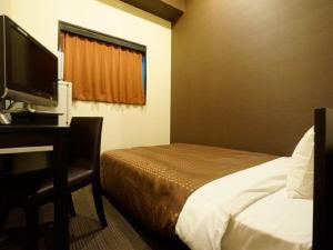 Postel nebo postele na pokoji v ubytování HOTEL LiVEMAX Osaka Namba