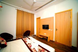 a hotel room with a bed and a desk and a television at Hotel Diamond View in Amritsar