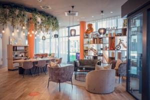 a living room with a table and chairs and a room withwindows at Adagio Access Stuttgart Airport Messe in Leinfelden-Echterdingen