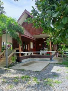 a wooden house with a porch and a patio at บาคัสโฮมลอร์ด in Haad Chao Samran