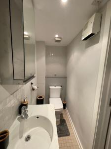 łazienka z białą umywalką i toaletą w obiekcie The Reflection Apartment , With river Thames view w mieście North Woolwich