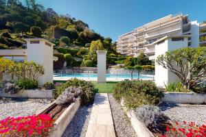 a view of a building and a garden with flowers at Studio les palmiers in Menton