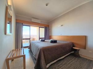 a hotel room with a bed and a balcony at OÁSIS Beach Apartment in Portimão +25 photos