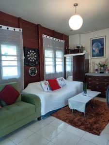 um quarto com uma cama, um sofá e uma mesa em บาคัสโฮมลอร์ด em Haad Chao Samran