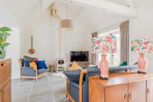 a living room with a blue couch and two chairs at The Barn at Kington Grange in Claverdon