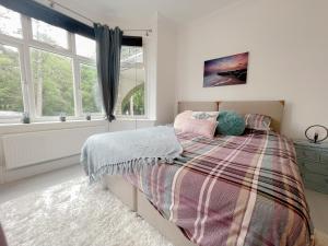 a bedroom with a bed and two windows at Queens Park View - 1 Bedroom in Bournemouth